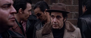 Movie still from “Donnie Brasco” (1997), directed by Mike Newell – A group of men standing next to each other on a street; Medium shot, Over the shoulder angle