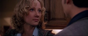 Movie still from “Donnie Brasco” (1997), directed by Mike Newell – A woman with blonde curly hair sitting in a room; Close Up shot, Over the shoulder angle