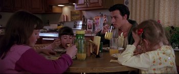 Movie still from “Donnie Brasco” (1997), directed by Mike Newell – A man and a woman sitting at a table with a little girl; Medium shot, High angle