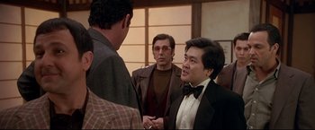 Movie still from “Donnie Brasco” (1997), directed by Mike Newell – A group of men standing next to each other in a room; Medium shot, Over the shoulder angle