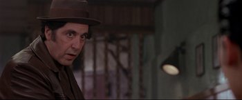 Movie still from “Donnie Brasco” (1997), directed by Mike Newell – A man wearing a hat standing in front of a lamp; Close Up shot, Over the shoulder angle