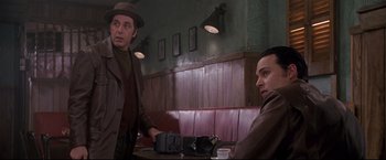 Movie still from “Donnie Brasco” (1997), directed by Mike Newell – Two men are sitting at a booth in a restaurant; Medium shot, Low angle