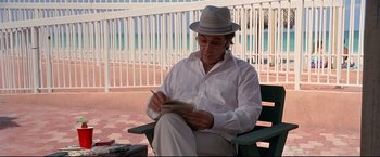 Movie still from “Donnie Brasco” (1997), directed by Mike Newell – An older man sitting on top of a wooden bench; Medium shot, Low angle