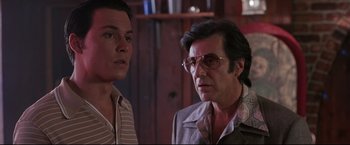 Movie still from “Donnie Brasco” (1997), directed by Mike Newell – A man and a man standing next to each other in a room; Close Up shot, Low angle