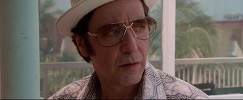 Movie still from “Donnie Brasco” (1997), directed by Mike Newell – A person wearing glasses and a hat; Close Up shot, Low angle