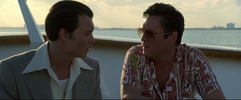 Movie still from “Donnie Brasco” (1997), directed by Mike Newell – A man and a man sitting next to each other on a boat; Close Up shot, Low angle
