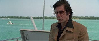 Movie still from “Donnie Brasco” (1997), directed by Mike Newell – A man in a brown jacket and glasses on a boat in the water; Close Up shot, Over the shoulder angle