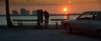 Movie still from “Donnie Brasco” (1997), directed by Mike Newell – A man standing next to a parking meter at sunset; Wide shot, Low angle