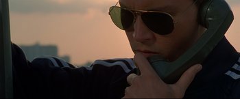 Movie still from “Donnie Brasco” (1997), directed by Mike Newell – A man wearing sunglasses is talking on a cell phone; Close Up shot, Low angle