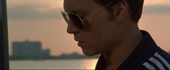 Movie still from “Donnie Brasco” (1997), directed by Mike Newell – A person wearing sunglasses near a body of water; Close Up shot, Low angle