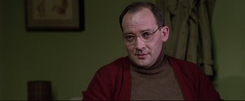 Movie still from “Donnie Brasco” (1997), directed by Mike Newell – A person wearing glasses and a sweater; Close Up shot, Over the shoulder angle