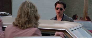 Movie still from “Donnie Brasco” (1997), directed by Mike Newell – A man looking into a mirror while standing next to a woman; Close Up shot, Over the shoulder angle