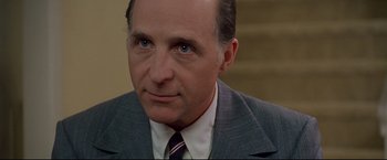 Movie still from “Donnie Brasco” (1997), directed by Mike Newell – A person wearing a suit and tie; Close Up shot, Over the shoulder angle