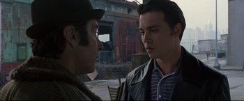 Movie still from “Donnie Brasco” (1997), directed by Mike Newell – Two men standing next to each other on a street; Close Up shot, Over the shoulder angle