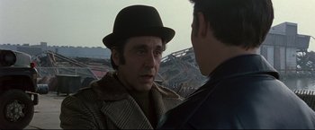 Movie still from “Donnie Brasco” (1997), directed by Mike Newell – A man wearing a hat talking to another man; Close Up shot, Over the shoulder angle