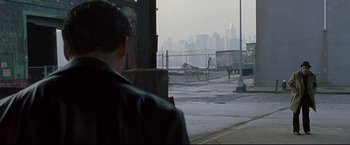 Movie still from “Donnie Brasco” (1997), directed by Mike Newell – A man standing in front of a fence looking at a city; Extreme Wide shot, Over the shoulder angle