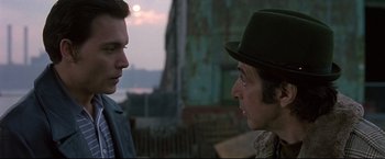 Movie still from “Donnie Brasco” (1997), directed by Mike Newell – Two men talking to each other in front of a fence; Close Up shot, Over the shoulder angle