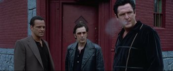 Movie still from “Donnie Brasco” (1997), directed by Mike Newell – A man standing in front of a red door; Medium shot, Low angle