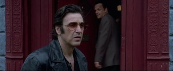 Movie still from “Donnie Brasco” (1997), directed by Mike Newell – A person wearing a suit and sunglasses; Close Up shot, Over the shoulder angle