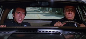 Movie still from “Earthquake” (1974), directed by Mark Robson – Two men sitting in the back seat of a car; Close Up shot, Low angle