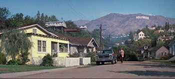 Movie still from “Earthquake” (1974), directed by Mark Robson – A man walking down the street near a car; Extreme Wide shot, Low angle
