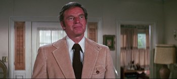Movie still from “Earthquake” (1974), directed by Mark Robson – A person wearing a suit and a tie; Medium shot, Over the shoulder angle