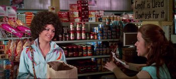 Movie still from “Earthquake” (1974), directed by Mark Robson – Two women are standing in a grocery store with food; Medium shot, Over the shoulder angle