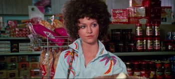 Movie still from “Earthquake” (1974), directed by Mark Robson – A woman in a blue shirt with a palm tree on it; Medium shot, Over the shoulder angle