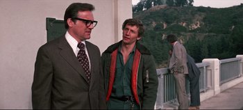 Movie still from “Earthquake” (1974), directed by Mark Robson – Two men standing next to each other on a bridge; Medium shot, Low angle