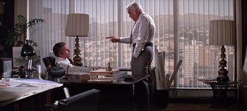 Movie still from “Earthquake” (1974), directed by Mark Robson – An older man standing in front of a desk; Wide shot, Over the shoulder angle