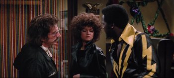 Movie still from “Earthquake” (1974), directed by Mark Robson – Two men and a woman are talking to each other; Medium shot, Over the shoulder angle