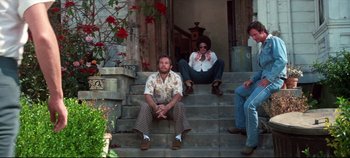 Movie still from “Earthquake” (1974), directed by Mark Robson – A group of people sitting on the steps of a house; Wide shot, Low angle