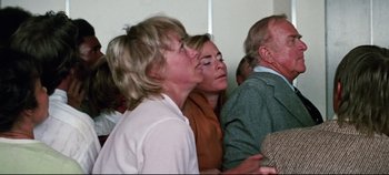 Movie still from “Earthquake” (1974), directed by Mark Robson – A group of people standing around each other; Medium shot, High angle