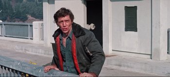 Movie still from “Earthquake” (1974), directed by Mark Robson – A man sitting on the ground in front of a building; Medium shot, Low angle