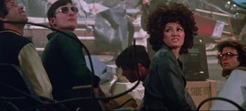 Movie still from “Earthquake” (1974), directed by Mark Robson – A group of people sitting in a room; Medium shot, Low angle