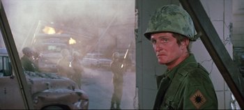 Movie still from “Earthquake” (1974), directed by Mark Robson – A man in a military uniform standing in front of a building; Close Up shot, Over the shoulder angle