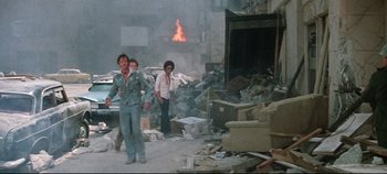Movie still from “Earthquake” (1974), directed by Mark Robson – A group of people standing in a room with a fire; Wide shot, High angle