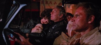 Movie still from “Earthquake” (1974), directed by Mark Robson – A man and a woman sitting next to each other; Medium shot, Over the shoulder angle