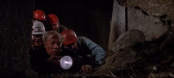 Movie still from “Earthquake” (1974), directed by Mark Robson – A group of people in the dark with a flashlight; Medium shot, High angle