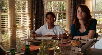 Movie still from “Easy A” (2010), directed by Will Gluck – Two people sitting at a table with a plate in front of them; Medium shot, Over the shoulder angle