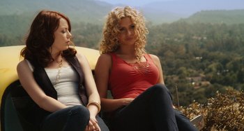 Movie still from “Easy A” (2010), directed by Will Gluck – Two beautiful women sitting on a bench in the mountains; Medium shot, Low angle