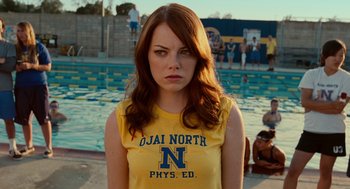 Movie still from “Easy A” (2010), directed by Will Gluck – A woman with long red hair wearing a t - shirt; Close Up shot, Over the shoulder angle