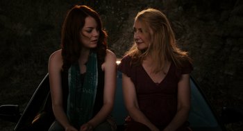 Movie still from “Easy A” (2010), directed by Will Gluck – Two women sitting next to each other in a dark room; Medium shot, Over the shoulder angle