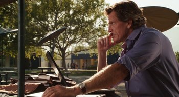 Movie still from “Easy A” (2010), directed by Will Gluck – A man sitting in front of an open laptop computer; Medium shot, Low angle