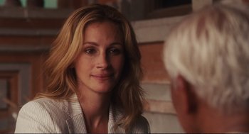 Movie still from “Eat Pray Love” (2010), directed by Ryan Murphy – A person sitting down; Close Up shot, Over the shoulder angle