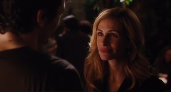 Movie still from “Eat Pray Love” (2010), directed by Ryan Murphy – A beautiful woman standing next to a man in a crowd; Close Up shot, Over the shoulder angle