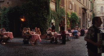 Movie still from “Eat Pray Love” (2010), directed by Ryan Murphy – A group of diners sitting at tables outside of a restaurant; Extreme Wide shot, High angle