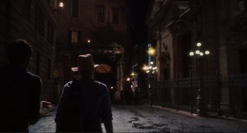 Movie still from “Eat Pray Love” (2010), directed by Ryan Murphy – A man with a hat walking down a street at night; Wide shot, High angle