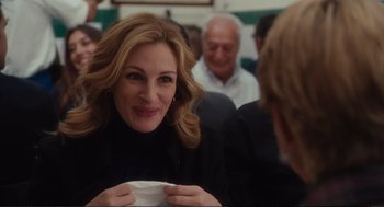 Movie still from “Eat Pray Love” (2010), directed by Ryan Murphy – A beautiful woman sitting in front of a group of people; Close Up shot, Over the shoulder angle