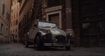 Movie still from “Eat Pray Love” (2010), directed by Ryan Murphy – An old car parked on the side of the street; Extreme Wide shot, High angle